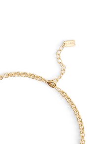 Gold chain bracelet featuring interlocking links, textured shine, a clasp closure, and a hanging tag embossed with "COACH."