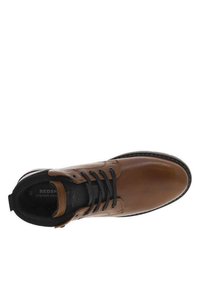 Chaussure en cuir marron avec des accents noirs, bout arrondi, six oeillets pour les lacets, surface texturée et couture contrastante le long de la semelle.