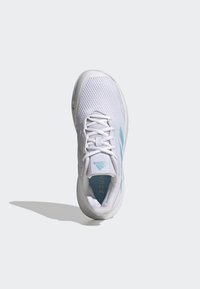 White athletic shoe with a textured mesh upper and light blue accents. Features a padded collar and flat laces. Round toe and rubber sole.