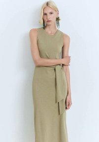 Olive green sleeveless dress with a fitted bodice and a tied waist detail. Soft, stretchy fabric drapes to a mid-calf length.