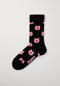 Svarta strumpor med ett upprepat mönster av rosa pixeliserade grisar, med ordet "HAPPY" i rosa text på botten. Mjuk textur.