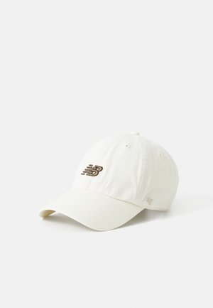 Casquette de baseball beige clair avec visière incurvée arborant un logo brodé New Balance marron foncé à l'avant et un petit logo "47" brodé sur le côté.