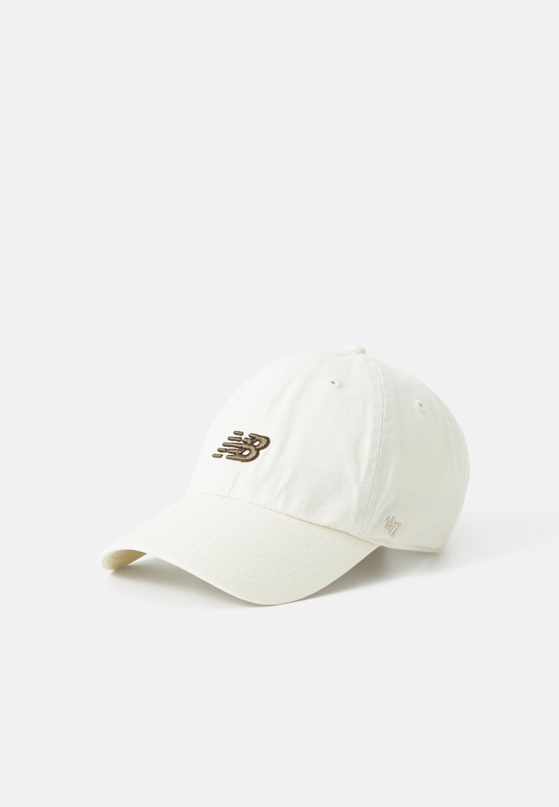 Casquette de baseball beige clair avec visière incurvée arborant un logo brodé New Balance marron foncé à l'avant et un petit logo "47" brodé sur le côté.