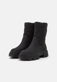 Schwarze Knöchelstiefel mit einem gesteppte Obermaterial, runder Zehenform und dickem, geripptem Profil. Hergestellt aus wasserdichtem Material für Langlebigkeit und einfachen Tragekomfort.