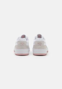 Baskets blanches avec des accents en daim gris clair, dotées d'une semelle en caoutchouc rose, d'un col rembourré et d'un logo au niveau du talon.