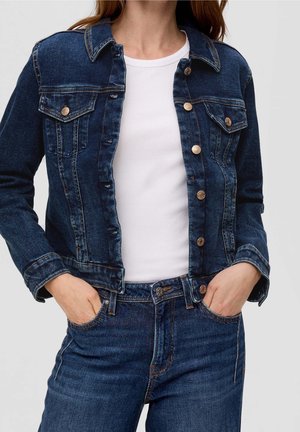 Granatowa kurtka dżinsowa z usztywnianym kołnierzem, przednimi kieszeniami, zapięciem na guziki oraz kontrastującymi przeszyciami. Nosi się ją na białą koszulę.