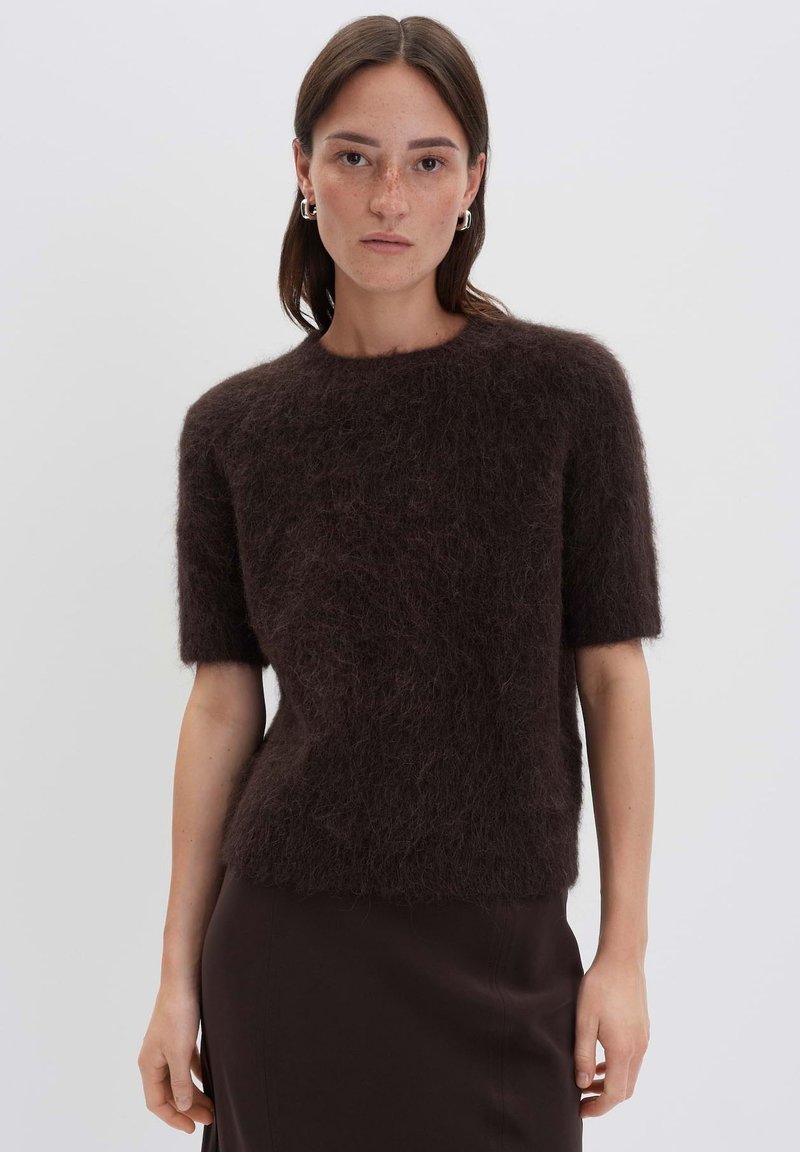 Pull en mohair mélangé marron à manches courtes avec une finition texturée et duveteuse et un col rond, associé à une jupe ajustée unie marron.