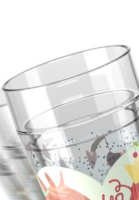 Transparentes Glas mit einer geschwungenen Form, das farbenfrohe Muster aus Punkten und Illustrationen auf der Oberfläche zeigt.