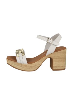 Sandalia blanca de plataforma con un tacón de madera grueso, presenta un diseño de doble correa y un acento decorativo dorado en la parte delantera.