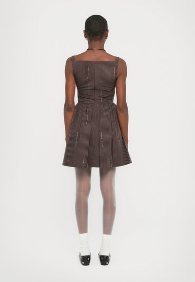 Bruin gestreepte jurk met een aansluitend lijfje en een uitlopende rok. Beschikt over slanke bandjes, verticale strepen en een elastische tailleband.