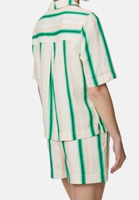 Kurzarmhemd mit Kragen, das vertikale grüne und rosa Streifen hat, kombiniert mit passenden Shorts. Hergestellt aus leichtem Baumwollstoff.