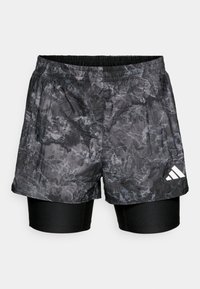 Svart og grå mønstrede treningsshorts lagd over tettsittende svarte under-shorts, med elastisk midjebånd og hvit merkevarelogo.