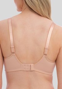Nafukovací podprsenka z jemného materiálu s nastavitelnými saténovými popruhy, subtilními vlnitými okraji a zapínáním na háček a oko na zadní straně pro bezpečné uchycení.