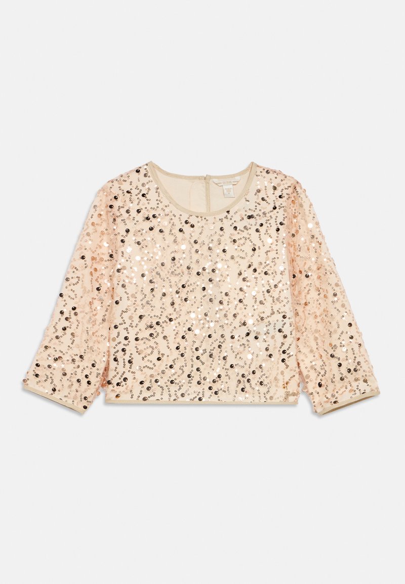 Top pailleté scintillant en pêche clair avec des manches trois-quarts et un col arrondi. Il présente un motif de paillettes sur l'ensemble et une doublure douce.