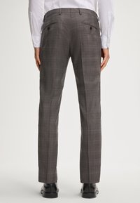 Grijze geruite broek met een slim fit, voorzien van twee achterzakken en een zachte textuur. Combinatie met zwarte schoenen.