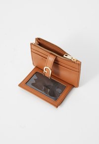 Brown leather wallet with a zip closure, card slots, and a clear ID window. Features a gold-toned hardware accent detail.