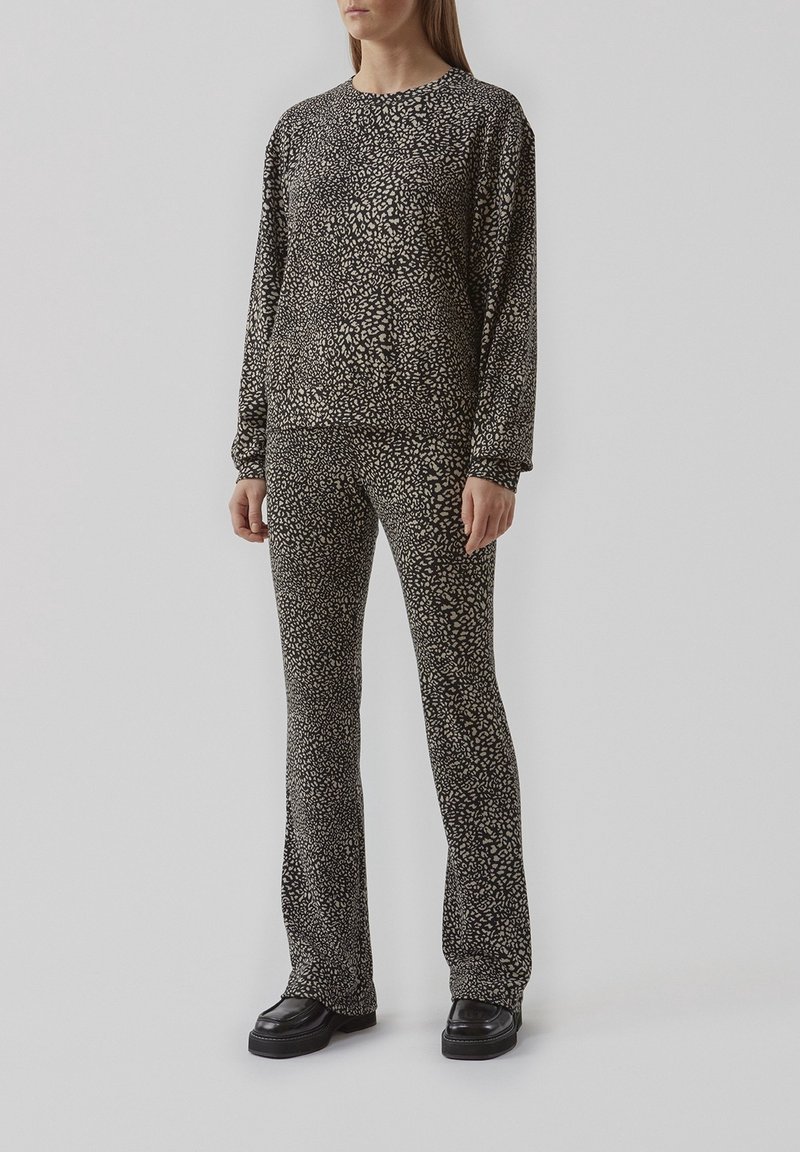 Zwart en beige gemarmerde lounge-kledingset, bestaande uit een langemouwen top en uitlopende broek, gemaakt van zachte stof met een gladde textuur.