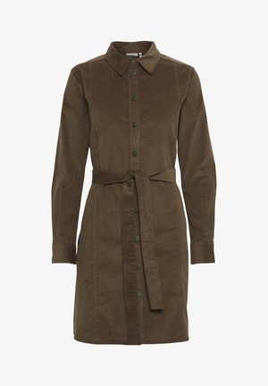 Abito camicia in velluto a coste marrone con colletto, maniche lunghe, chiusura frontale con bottoni e cintura in vita con fiocco. Texture liscia e taglio dritto.