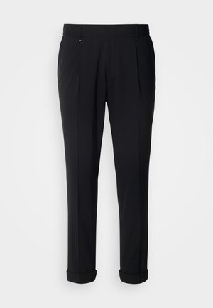 Schwarze, maßgeschneiderte Hosen mit glatter Textur, flacher Vorderseite, einzelnen Falten und umgeschlagenen Säumen für einen eleganten Look.