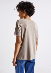 Camiseta gris de manga corta con una textura suave y un corte relajado, que presenta un escote redondeado y sutiles rayas horizontales.