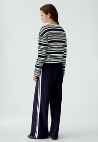 Gestreepte lange mouwen top in marineblauw en roomwit met een ronde hals, gecombineerd met marineblauwe broek met witte zijstrepen, van zachte stof en met een relaxte pasvorm.