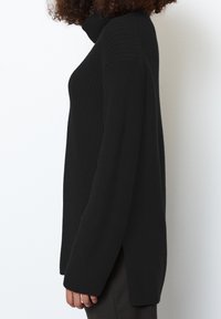 Maglione nero a collo alto in maglia con un motivo testurizzato, maniche lunghe, fessure laterali e una vestibilità rilassata.