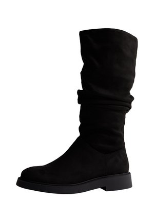 Botte noire en daim mi-mollet avec semelle plate et talon léger, présentant un design supérieur relâché et un bout arrondi.