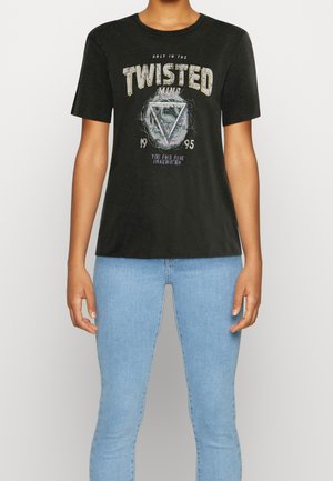 Persoon draagt een zwart T-shirt met de tekst "TWISTED MIND" en een driehoekige afbeelding, gecombineerd met lichtblauwe spijkerbroek, tegen een effen achtergrond.
