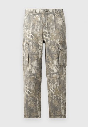 Pantaloni cargo cu un model de camuflaj, având nuanțe de marron și bej. Construiți dintr-un material durabil, cu multiple buzunare laterale și detalii cusute.