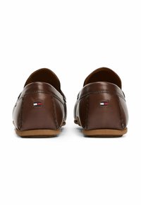 Scarpe slip-on in pelle marrone con retro arrotondato, cuciture a contrasto e un piccolo logo tricolore sul tallone. Suole in gomma per una buona aderenza.