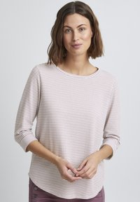 Lichtroze patroontop met driekwartmouwen, ronde halslijn en textiele stof, met een subtiel rasterachtig ontwerp.