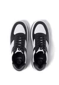 Scarpe da atletica in bianco e nero con tomaia in pelle liscia, punta perforata, chiusura con lacci e suola con motivo.