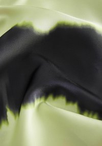 Satin stof met een gradientpatroon; limoen groen dat overgaat in zwart, met een soepele textuur en subtiele glans.