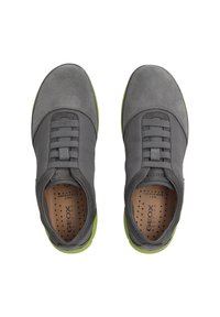 Grijze suède en stof sneakers met een gestructureerde afwerking, voorzien van een groene rubberen zool en elastische banddetails voor een veilige pasvorm.
