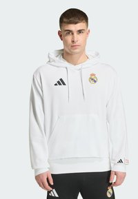 White hoodie made of cotton-blend fabric featuring a front pocket, drawstring hood, and black Adidas logo on the left chest.