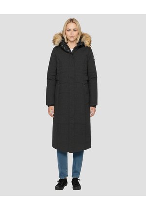 Abrigo largo negro acolchado con capucha forrada de pelo sintético, con cierre de cremallera, textura acolchada y bolsillos laterales, combinado con vaqueros azules y zapatos negros.