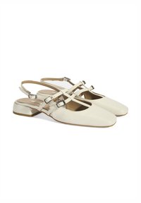 Cream leather slingback shoes with square toes, featuring crisscross straps and buckles, low block heel, and smooth texture.