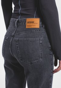 Jeans in denim grigio scuro con etichetta in pelle con la scritta "DRDENIM". Design a cinque tasche con cuciture a tono e vestibilità classica.