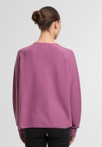 Vijolični ohlapen pulover z teksturiranim pletenjem, širokimi dolgimi rokavi in ravnim zaključkom spodaj, zasnovan za sproščen videz. Prikazan je zadnji pogled.