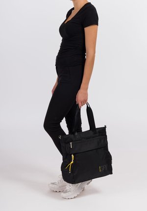 Zwarte totebag met een textuur oppervlak, dubbele handgrepen bovenaan, meerdere met rits afsluitbare compartimenten en een gele accent detail. Ideaal voor veelzijdig gebruik.
