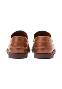 Bruna läderloafers med en slät textur, med en sömnadsdetalj på tån och ett präglat varumärke på hälen. Platt gummisula.