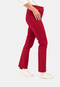 Rode katoenen broek met een slim fit, met een middelhoge taille, twee achterzakken en een gladde textuur, gecombineerd met witte sneakers.