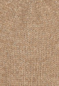 Berretto lavorato a maglia di colore beige chiaro, caratterizzato da un motivo testurizzato con punti visibili, realizzato in morbido materiale in lana o acrilico.
