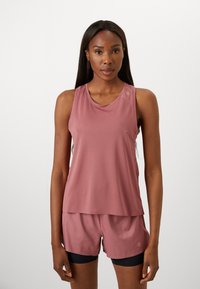 Activewear set featuring a sleeveless, light pink top and matching shorts. Fabric is soft with a smooth texture; top has a rounded neckline and subtle logo detail.