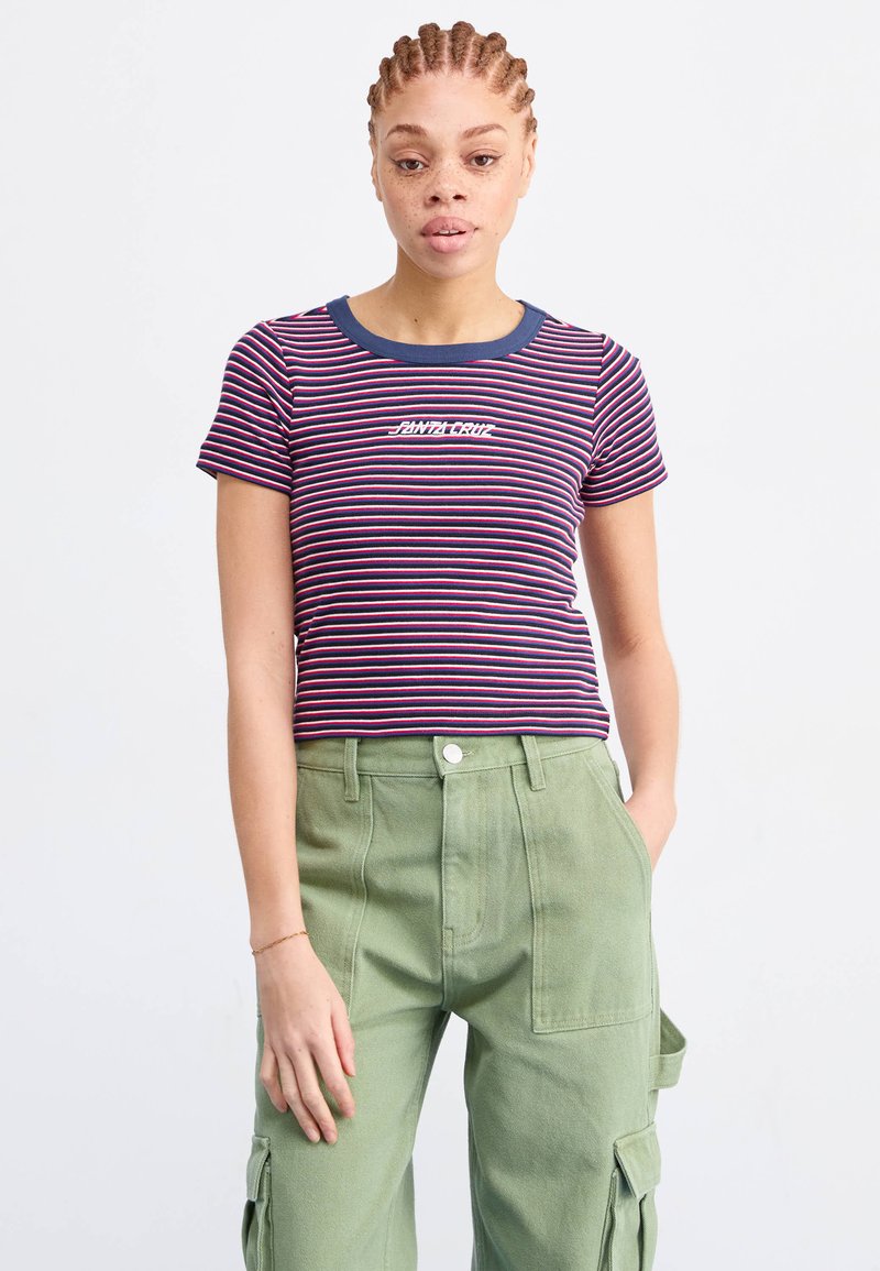 T-shirt a righe in navy, rosso e bianco con scollatura a girocollo e testo "Santa Cruz". Abbinato a pantaloni cargo verde oliva a vita alta.