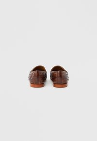 Καφέ υφαντά δερμάτινα μοκασίνια με χαμηλό προφίλ και στρογγυλεμένη μύτη. Διαθέτουν λείο, υφασμένο φινίρισμα και ταμπά λαστιχένιες σόλες.