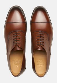 Braune Lederdressschuhe mit glatter Oberfläche, runder Zehenform, Schnürdesign und minimalen Nähdetails entlang der Kanten.