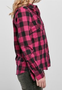 Fuchsia och svart rutig flanellskjorta med knappfront, långa ärmar och bröstficka, med rak nederkant och uppvikta ärmar.