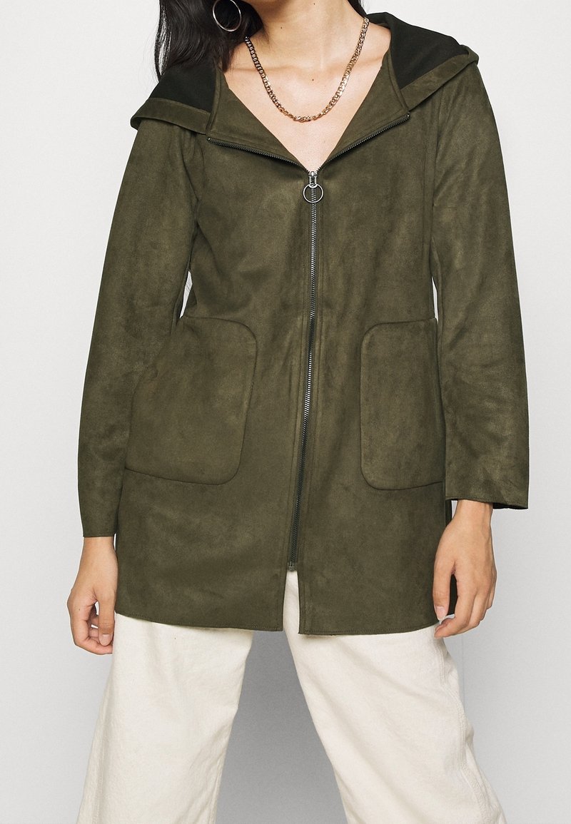 Olivgrön zip-up jacka i mjukt, mockaliknande material. Har en stor huva och två framfickor med en avslappnad passform.