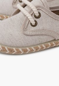 Scarpa in tessuto beige chiaro con texture in canvas, punta tondeggiante, lacci in corda e suola in juta intrecciata con cuciture alternate marroni e bianche.